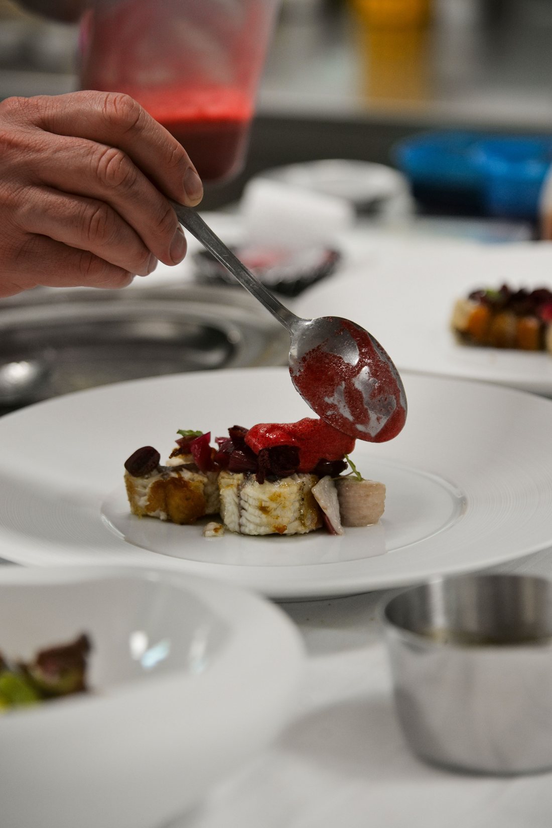 Chefs plating a gourmet dish in a professional kitchen